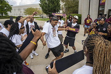 Mentors and staff members celebrate incoming IMPACT students with a dance tunnel