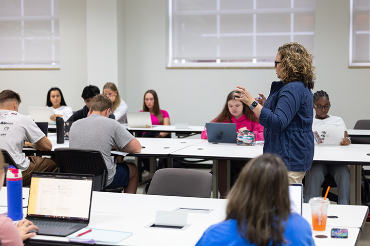 A faculty member addresses a classroom full of students