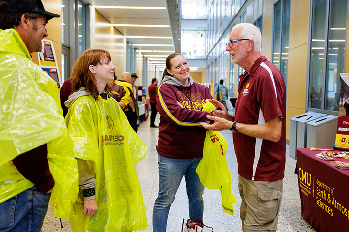 A prospective CMU student and her parents talk to a professor while standing in the hallway
