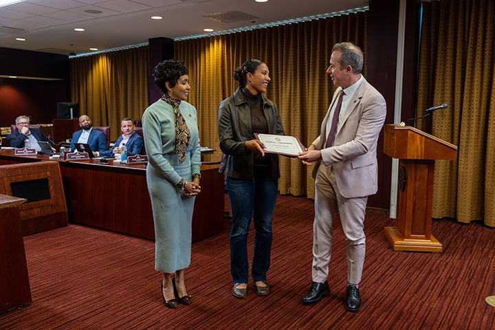 President MacKinnon hands a certificate to student athlete Gracie Merrick