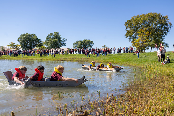 Contestants in the cardboard boat race hurry to the finish