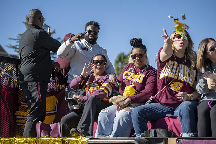 People throw candy from a float during the homecoming parade