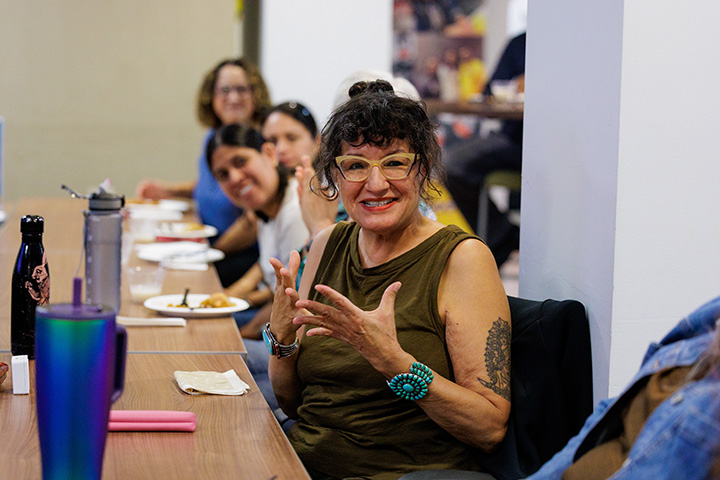 Author Sandra Cisneros talks to a group of students at a long table