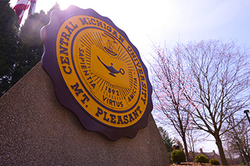 A round maroon and gold sign reading Central Michigan University Mt. Pleasant.