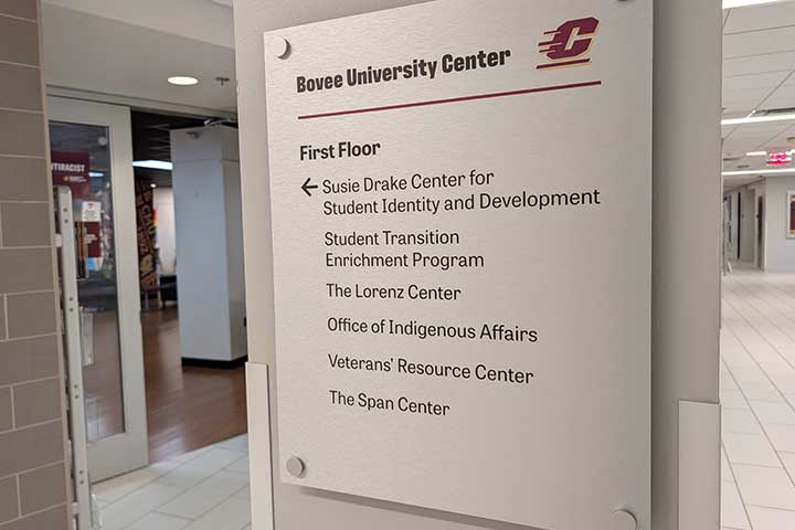 A light silver directional sign features the names of several CMU offices