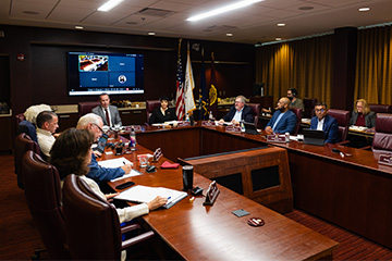 A group of people sitting around a table in a board room.