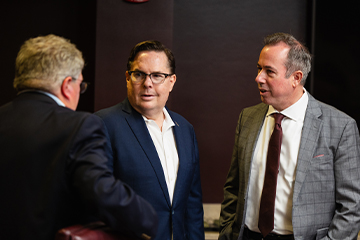 Three men in suits having a discussion.