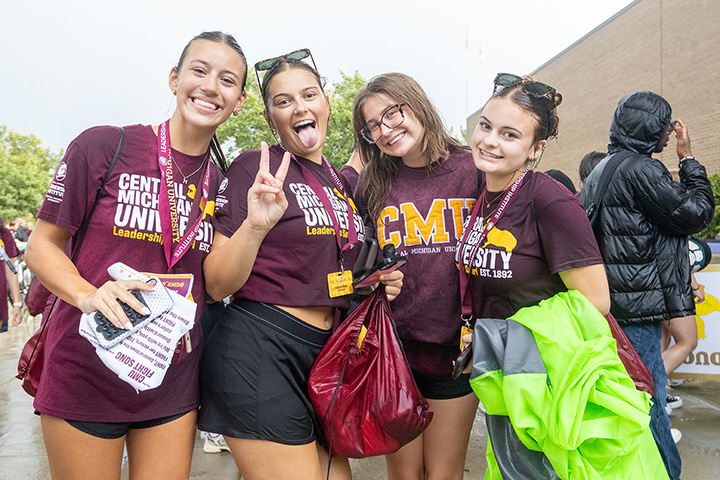 Four young women in maroon T-shirts smile for the camera