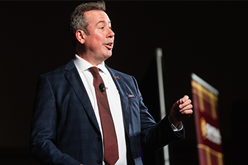 A man in a suit and tie speaking