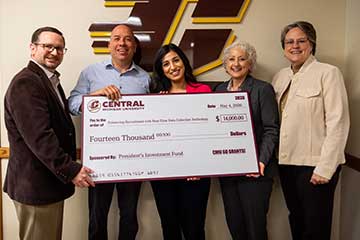 Five adults stand in front of the CMU Action C holding a large check for a Go Grant Initiative