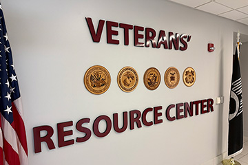 A wall with the words Veterans Resource Center on it, flanked by two flags