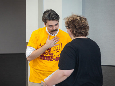 A man with a mustache holding his hand on his chest.