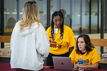 A group of women looking at a laptop.