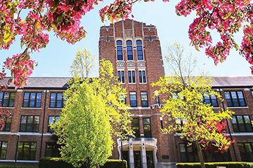 Warriner Hall with cherry blossom trees in the foreground.