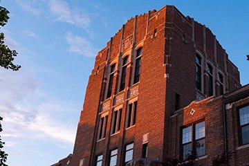 The front of Warriner Hall with blue sky and clouds