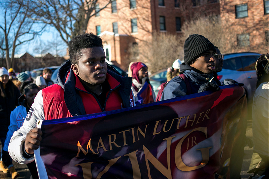 Students holding up a banner of Martin Luther King Jr. during the annual MLK Week march