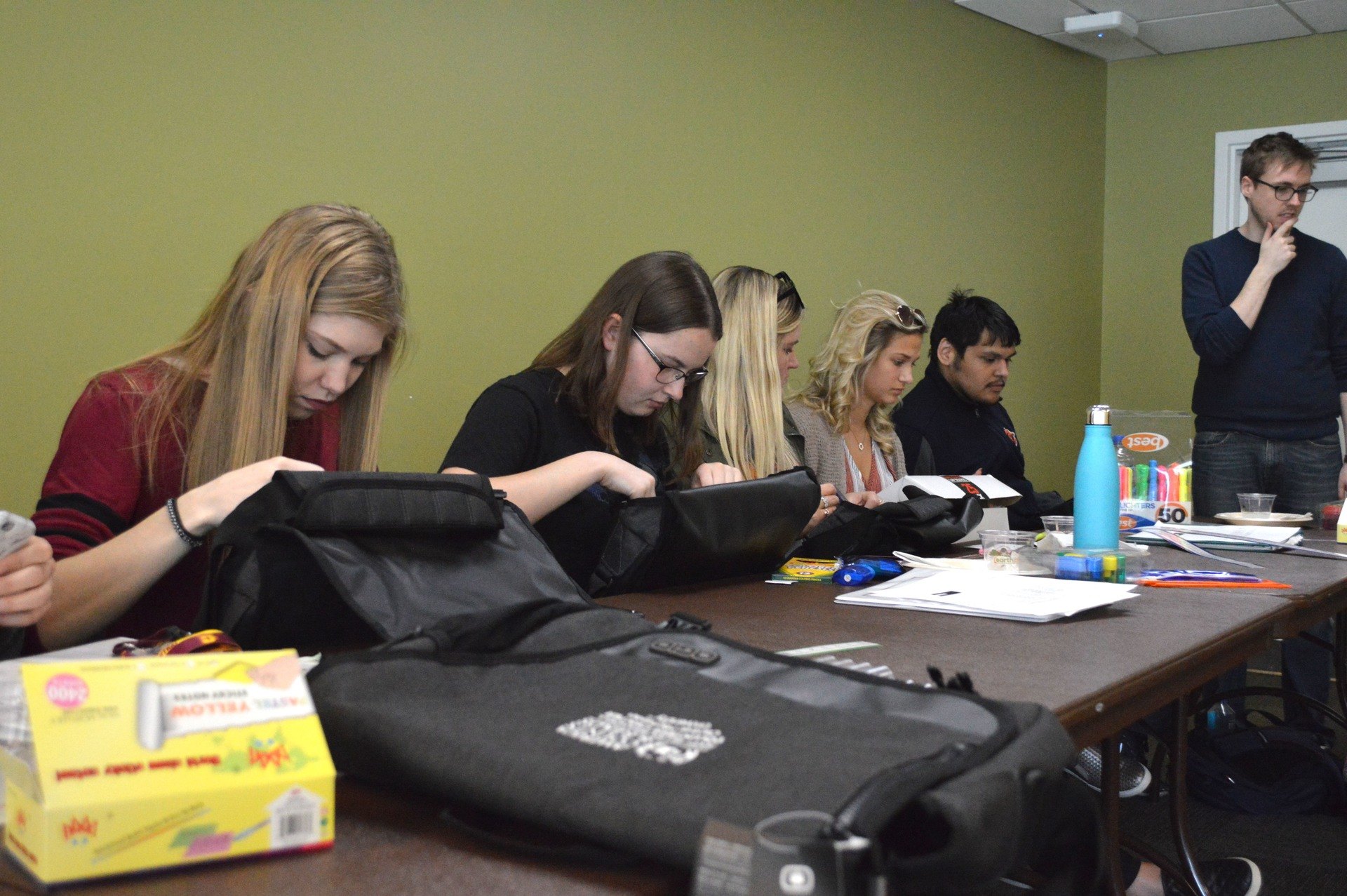 A group of student volunteers stuffing bags.