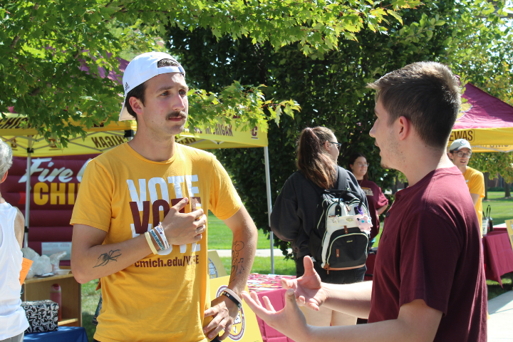 Student Coordinator for Central Votes, Harry, talks with another CMU students at the annual Fire Up the Vote event.