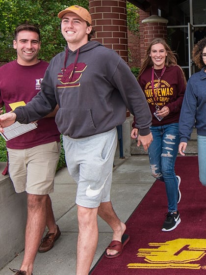 Group of students walking out of East Campus Residence during move-in day.