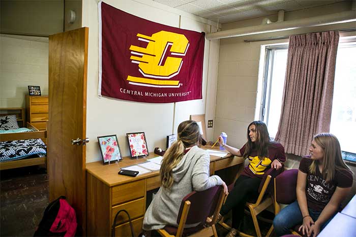 Three girls talking and studying in a dorm room in Herrig Hall.