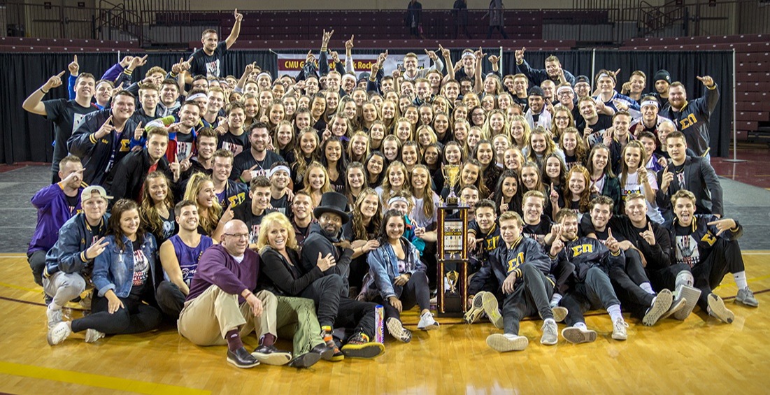 Central Michigan fraternity and sorority members pose for group shot on basketball court