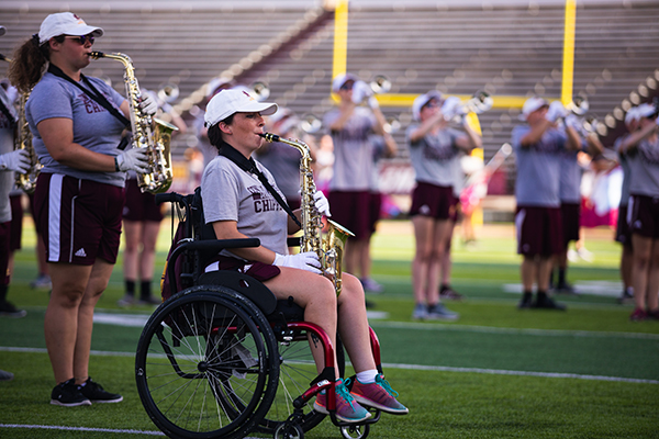 Marching band member in wheelchair playing saxophone