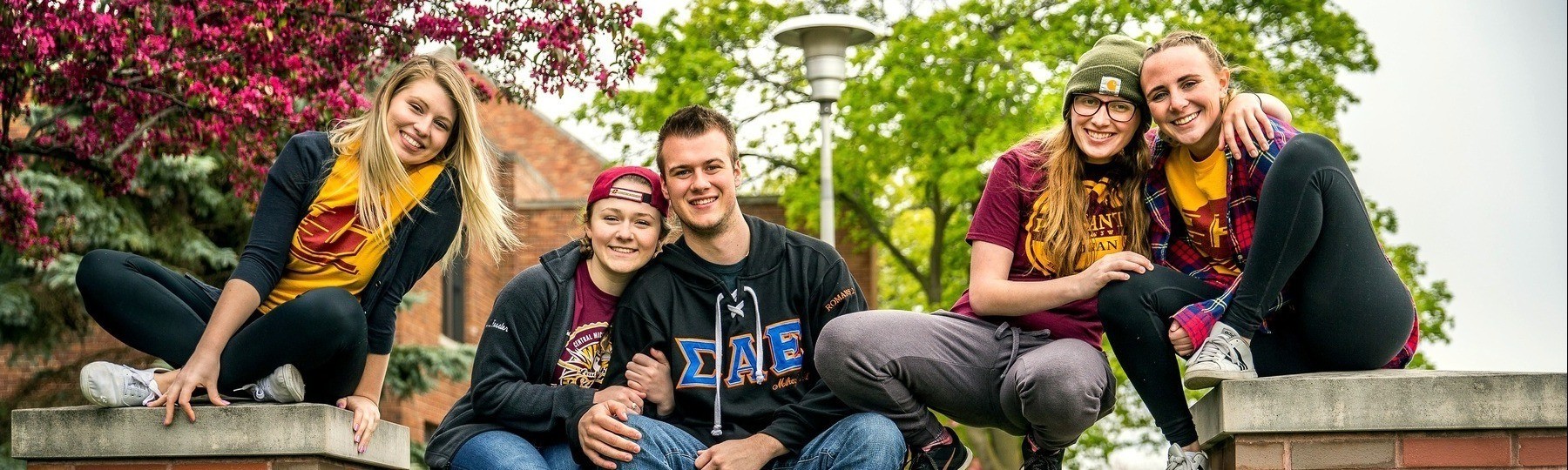 Sarah R. Opperman Leadership Institute student sitting on sign