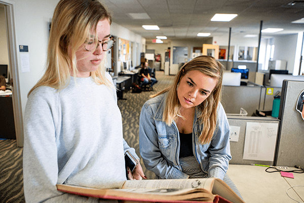 Two Central Michigan Life students reviewing page layouts.