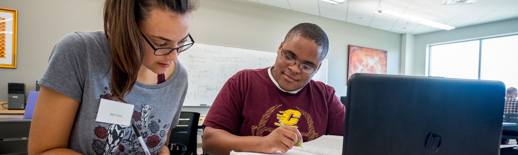 A Central Michigan University student tutoring another student at the Writing Center in Park Library.