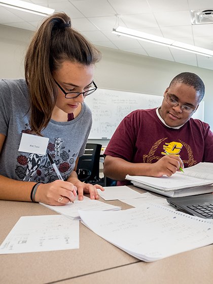 A Central Michigan University student tutoring another student at the Writing Center in Park Library.