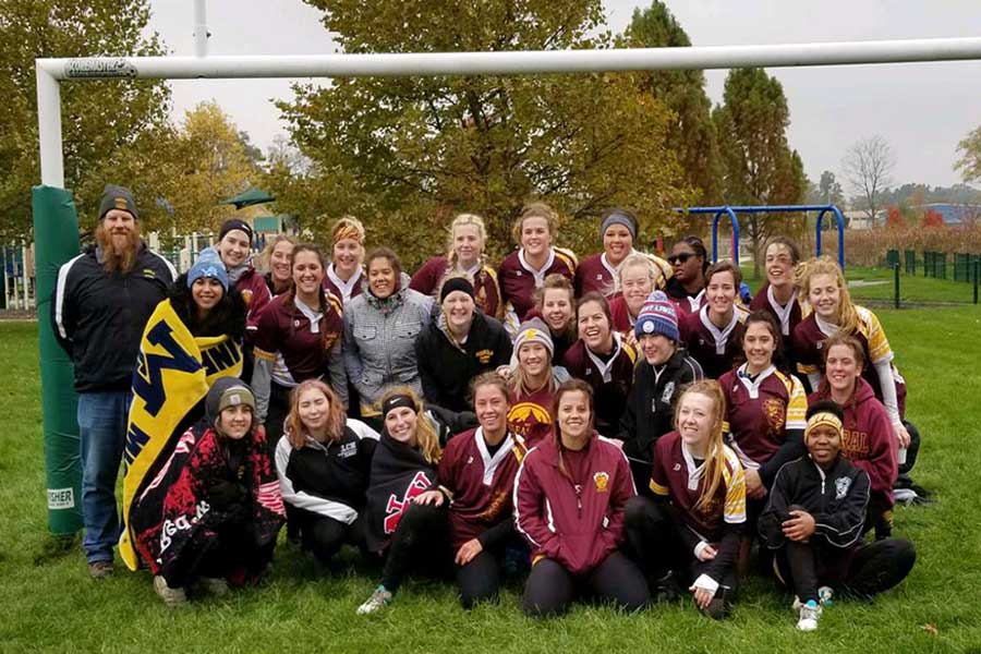 CMU club sports team gathered for group photo at a park