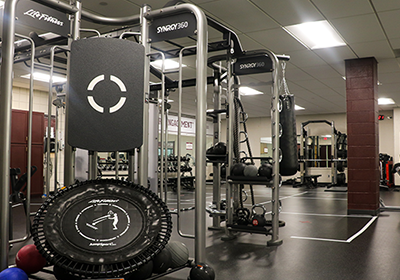A room with gym flooring and exercise equipment.