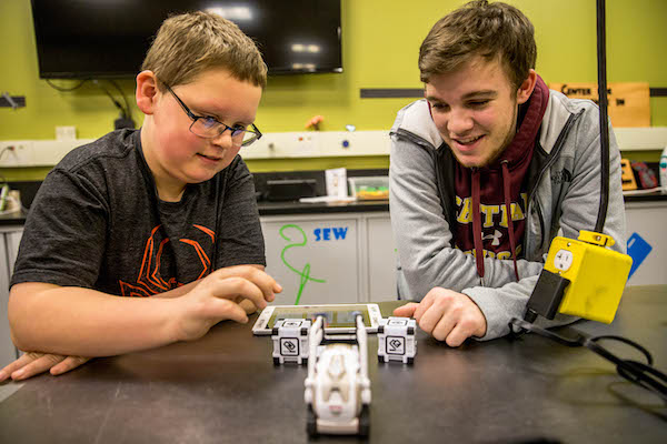 CMU student working with grade school aged student on a science project 