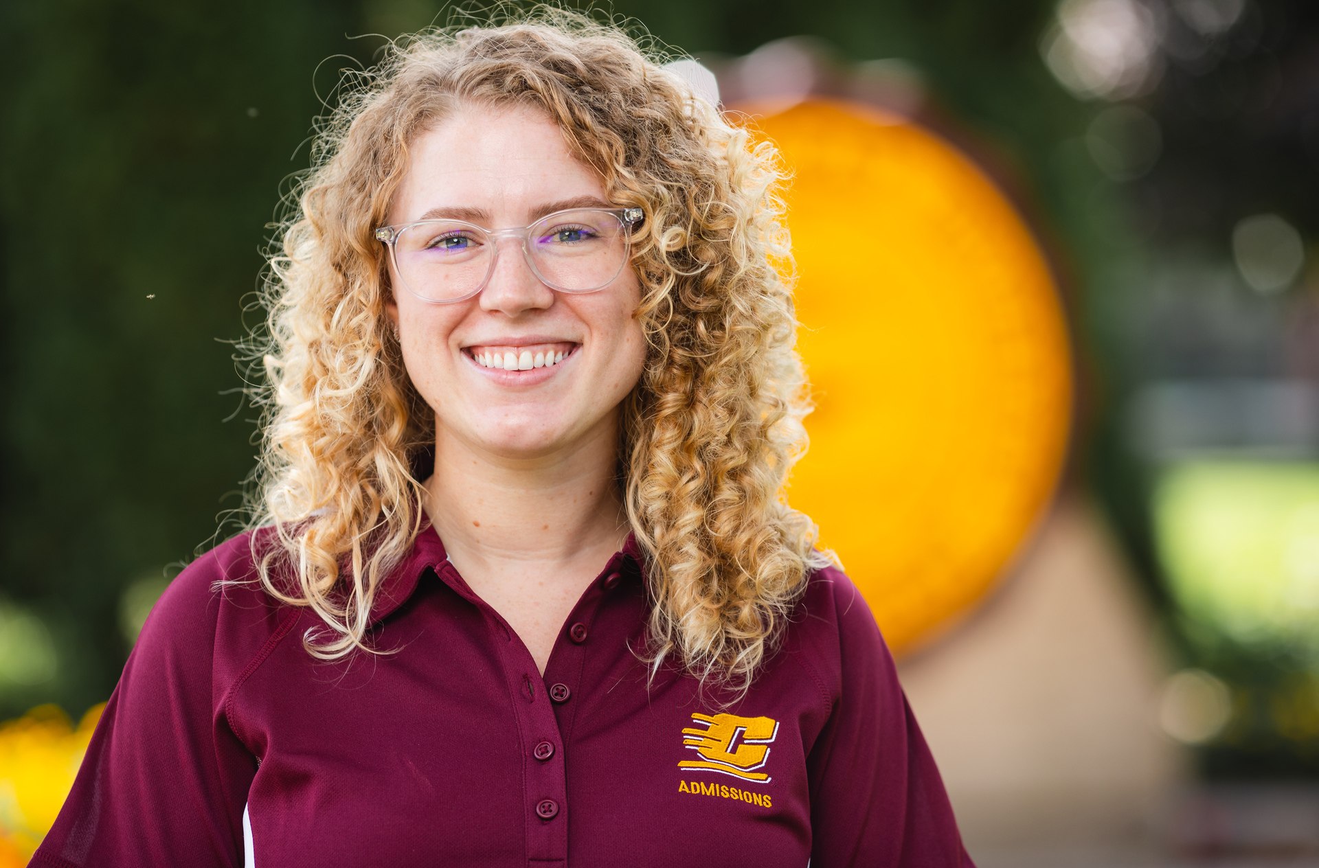 Professional headshot of Maggie Voisin in CMU attire against a blurred background.