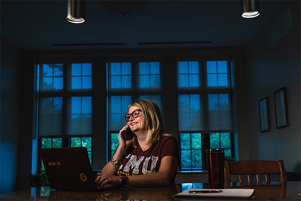 Student on phone with laptop