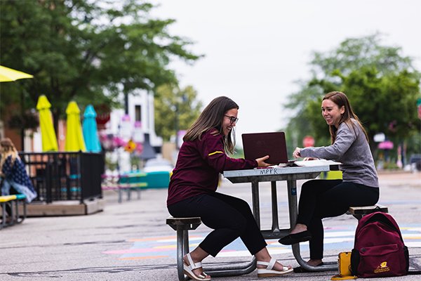 Students talking at an outdoor table