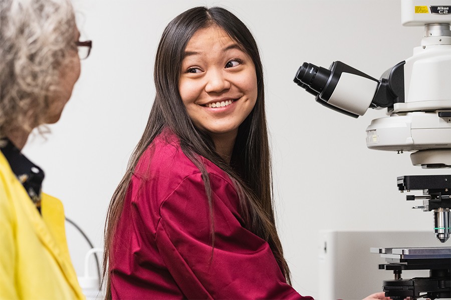 graduate assistant in a lab with microscope