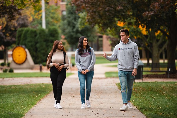 CMU students walking on campus by the seal