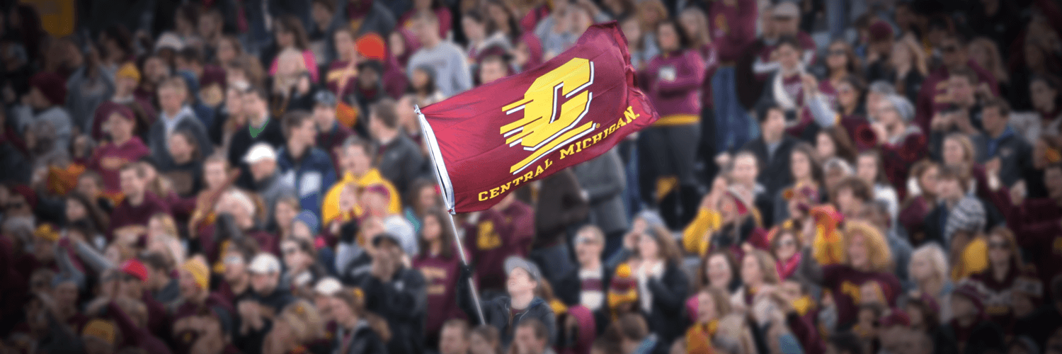 Student raising Central Michigan flag in the crowd