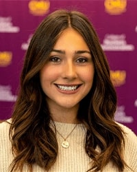 Carmella Cortes wears a light sweater and smiles for a staff photo.