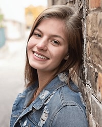 Kaylynne Costello wears a light blue jacket and smiles for a staff photo.