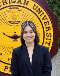 Mia Phan wears a black blazer and smiles for a staff photo.