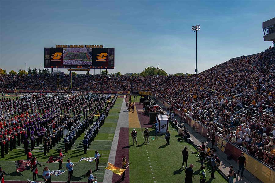 photo of CMU fans watching the Marching Chippewas and local bands marching at halftime