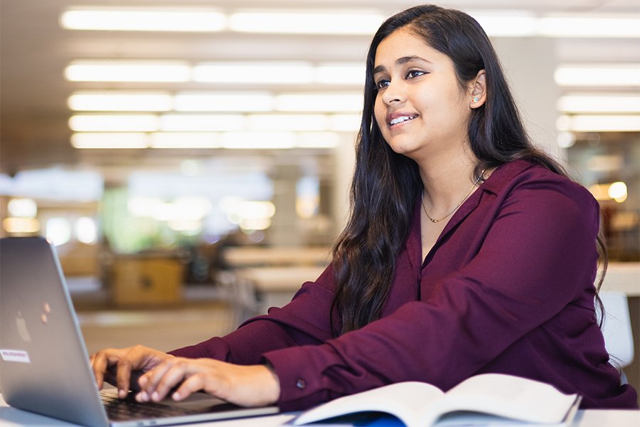 student at desk with laptop