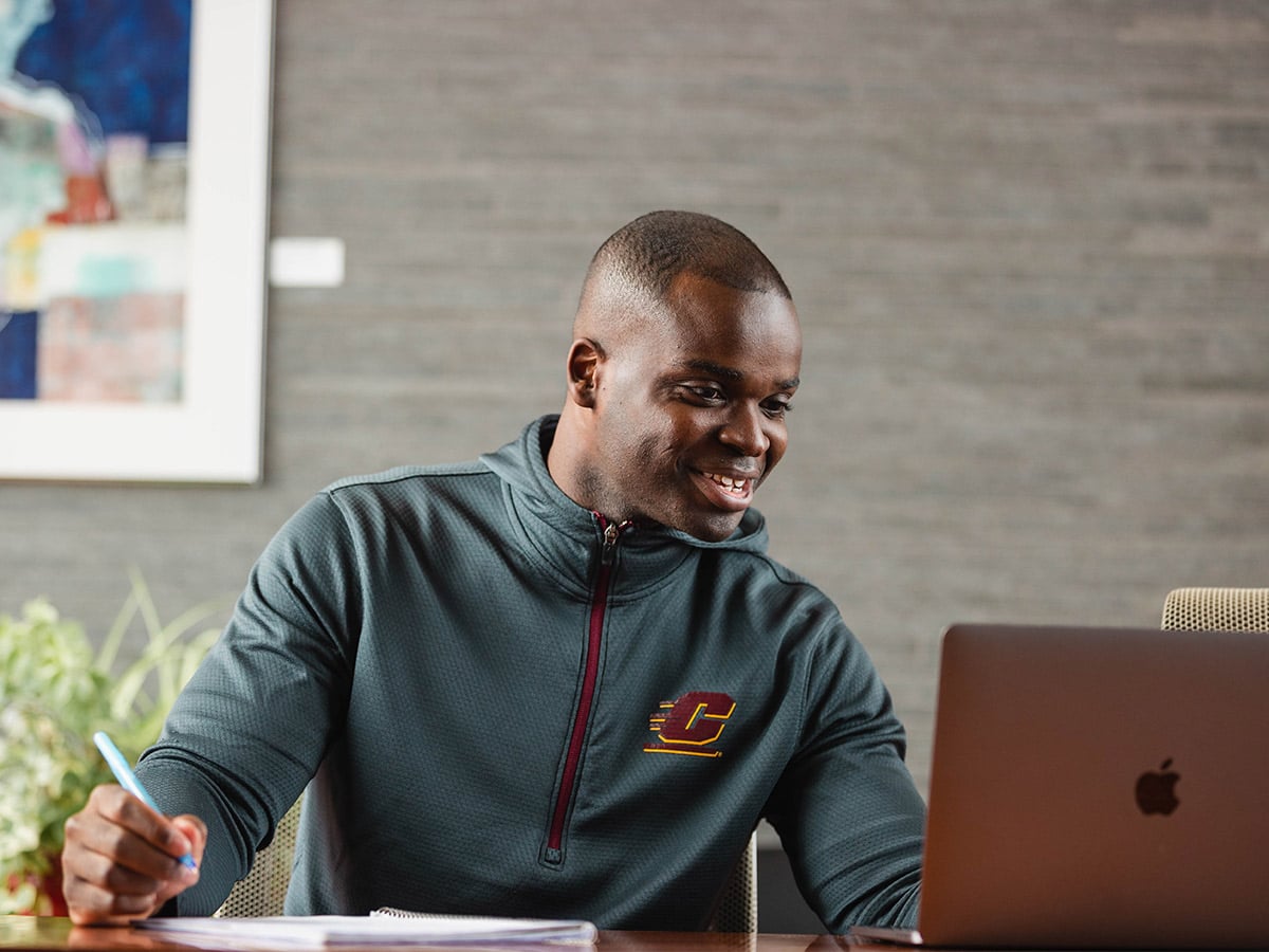 military student working on a laptop while taking an online class.