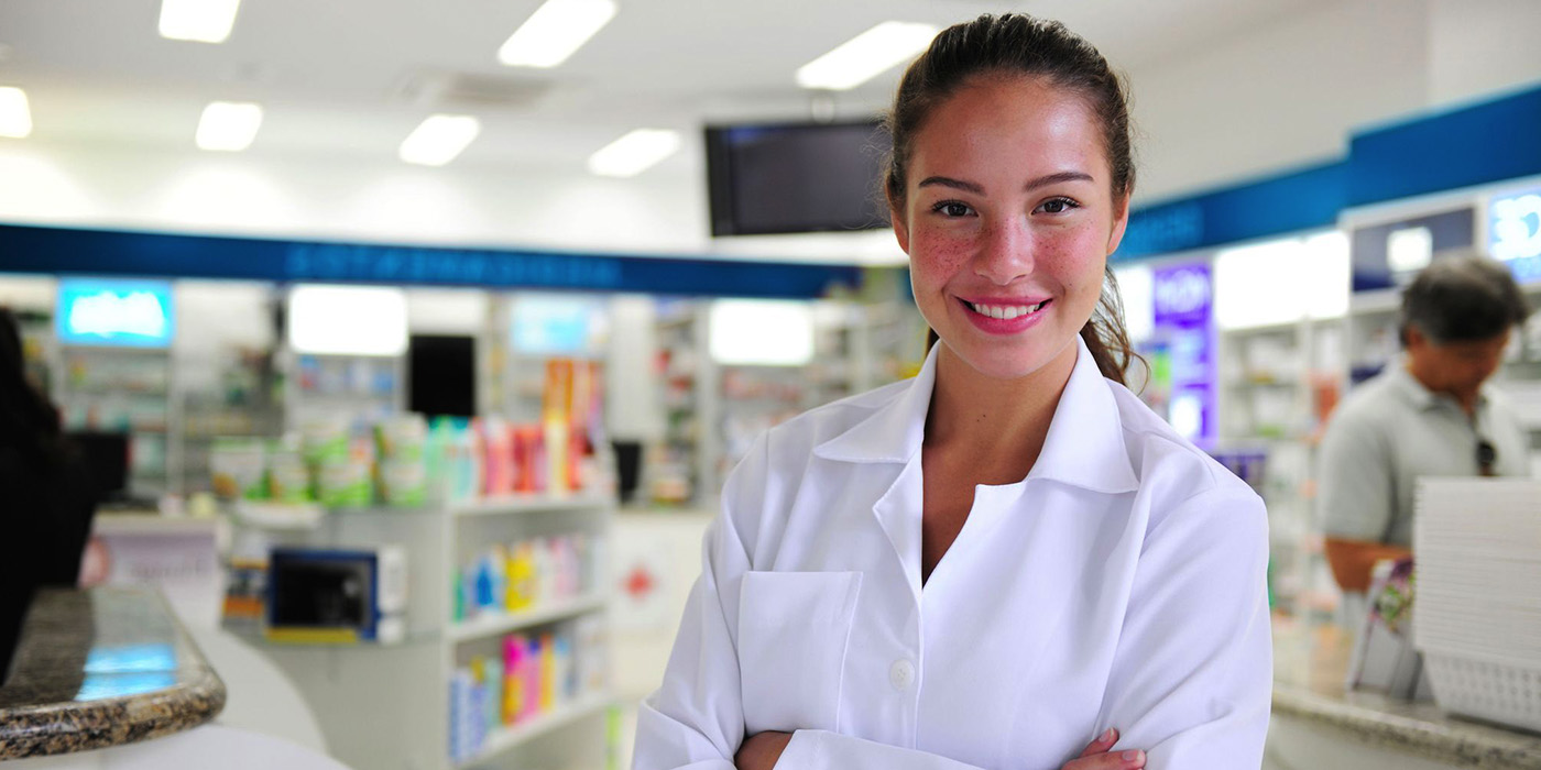 product-ges117-pharmacy-tech A pharmacy technician with dark hair wears a white lab coat.