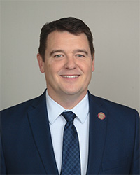 Mark Tapp wears blue suit while posing for a headshot.