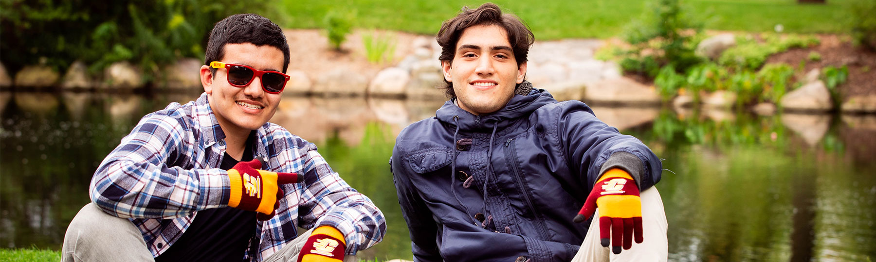 Two international students sitting on the lawn on CMU's campus.