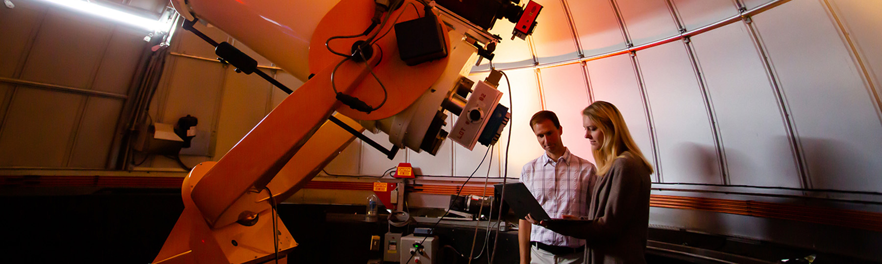 McNair Scholar and faculty member using large telescope