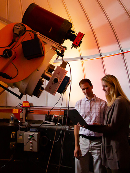 McNair Scholar and faculty member using large telescope